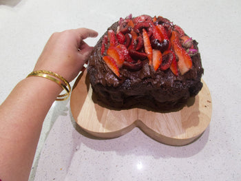 Chocolate cake topped with fresh strawberries, cherries