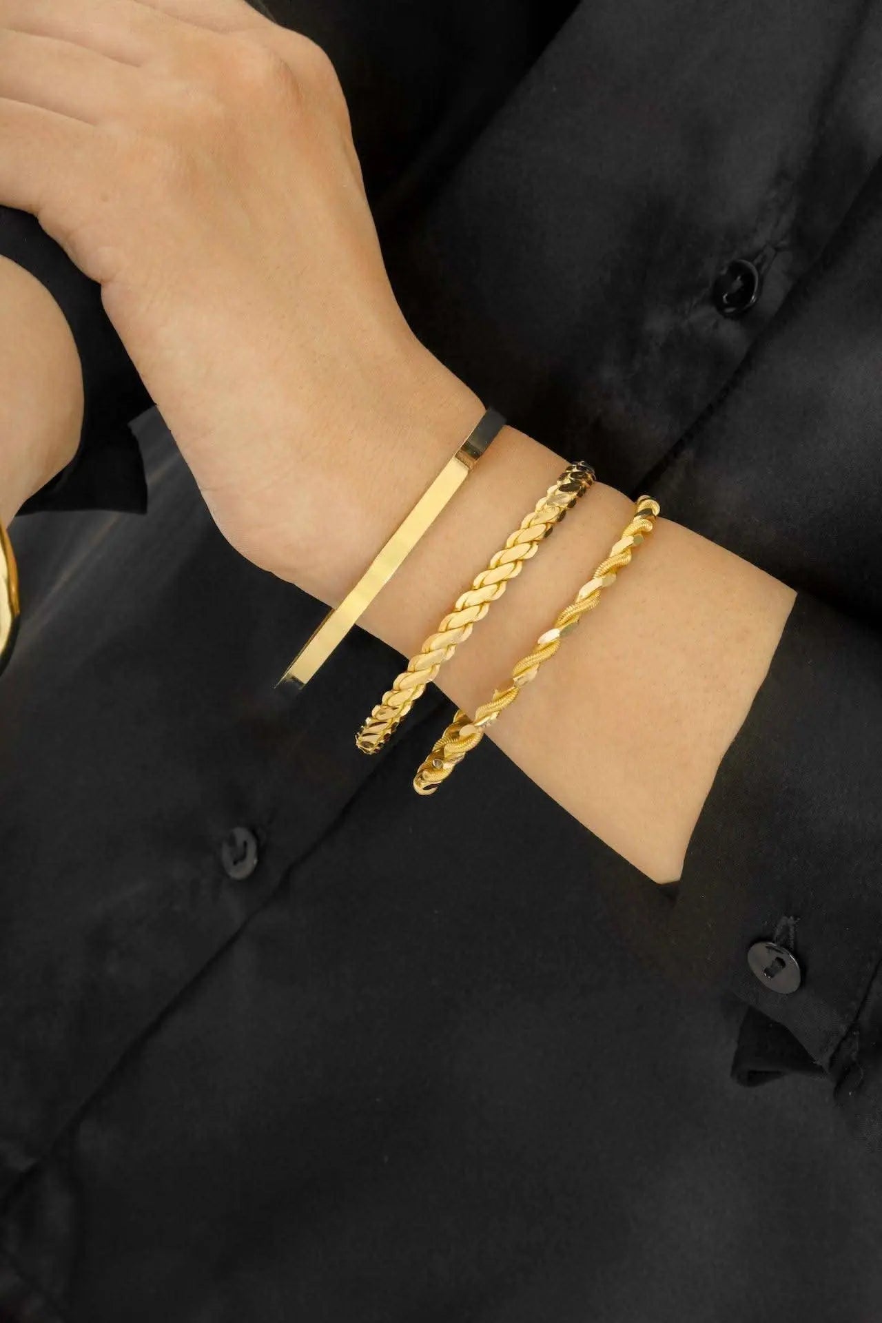 Woman wearing 22K gold bangle eclisse classic collection demonstrating elegant classic style on wrist, Chrysus Golds